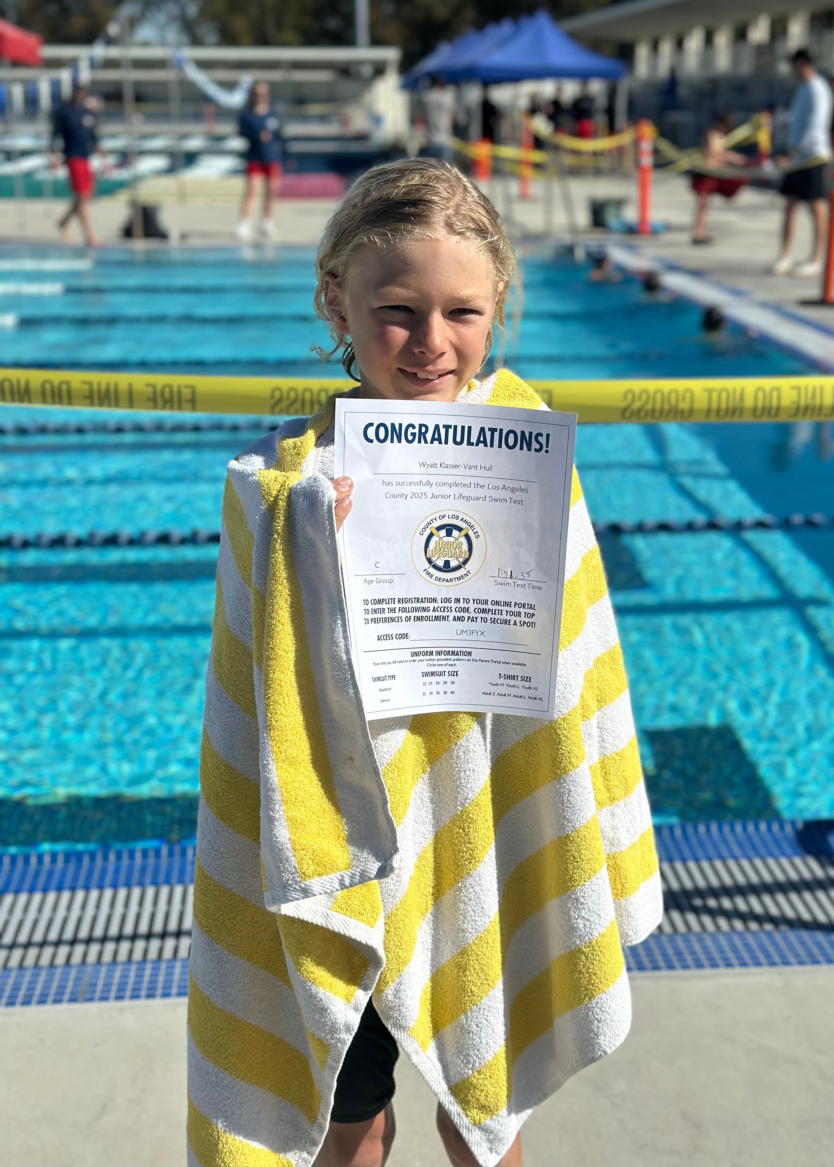 Junior Lifeguard candidate wrapped in a towel after passing his swim test