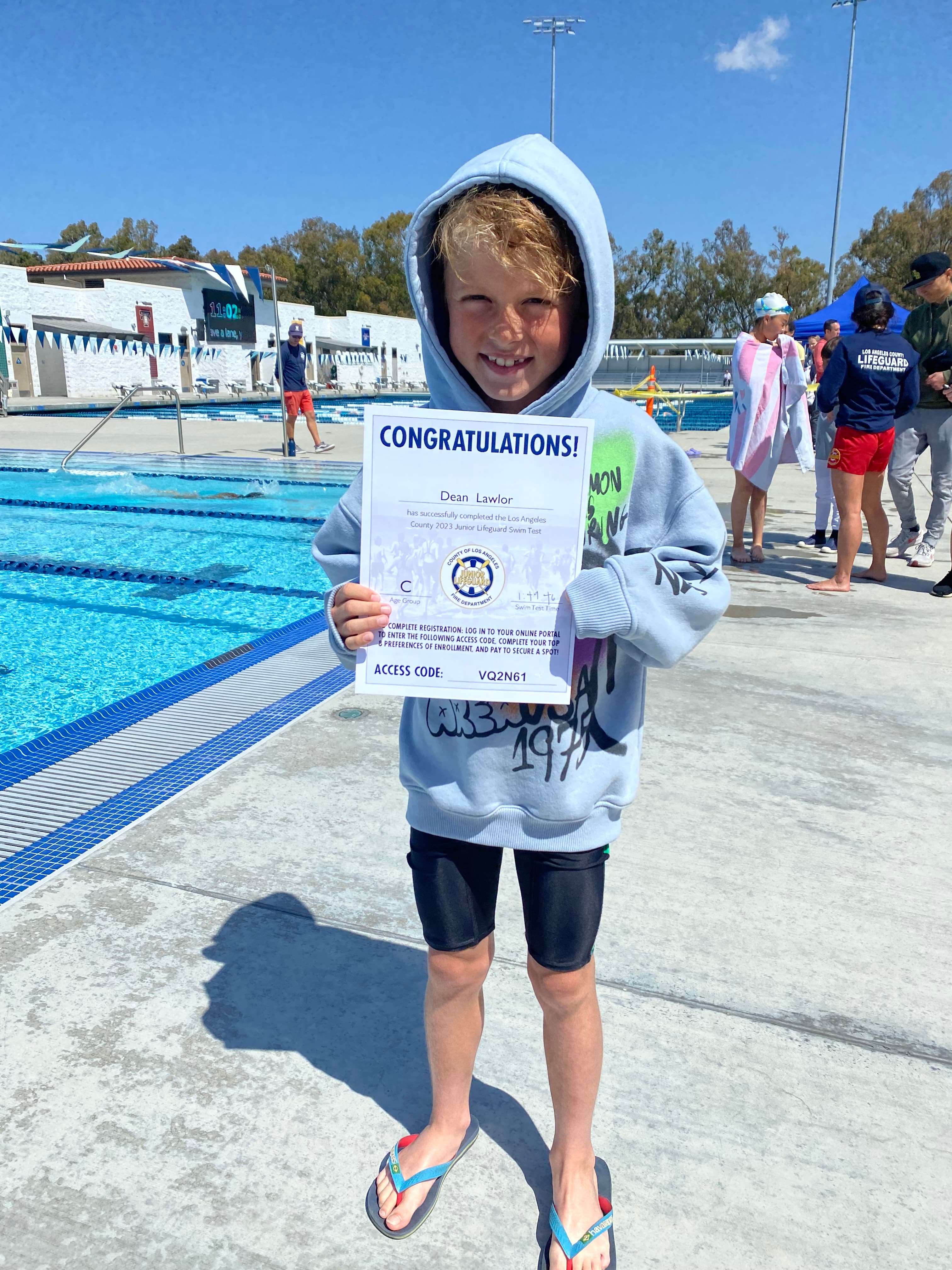 Junior Lifeguard candidate with his swim test certificate poolside