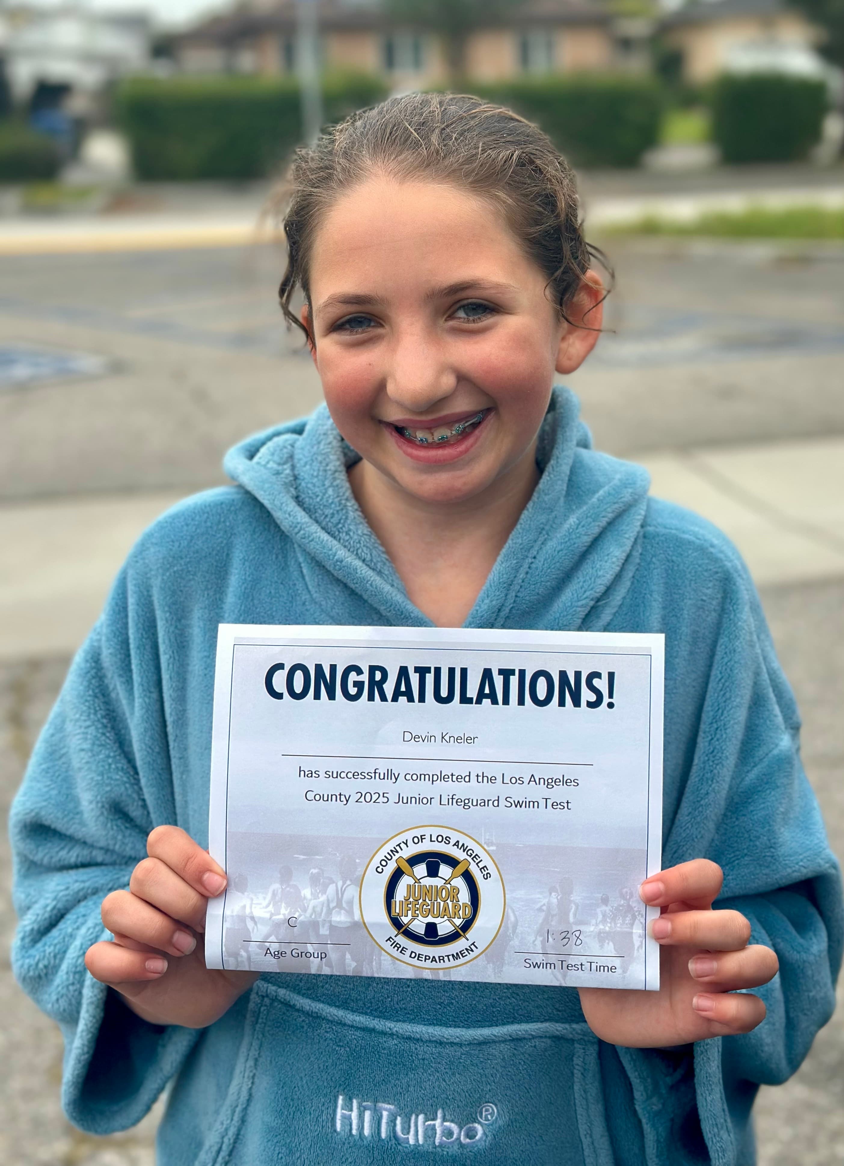 Smiling Junior Lifeguard candidate with her swim test certificate