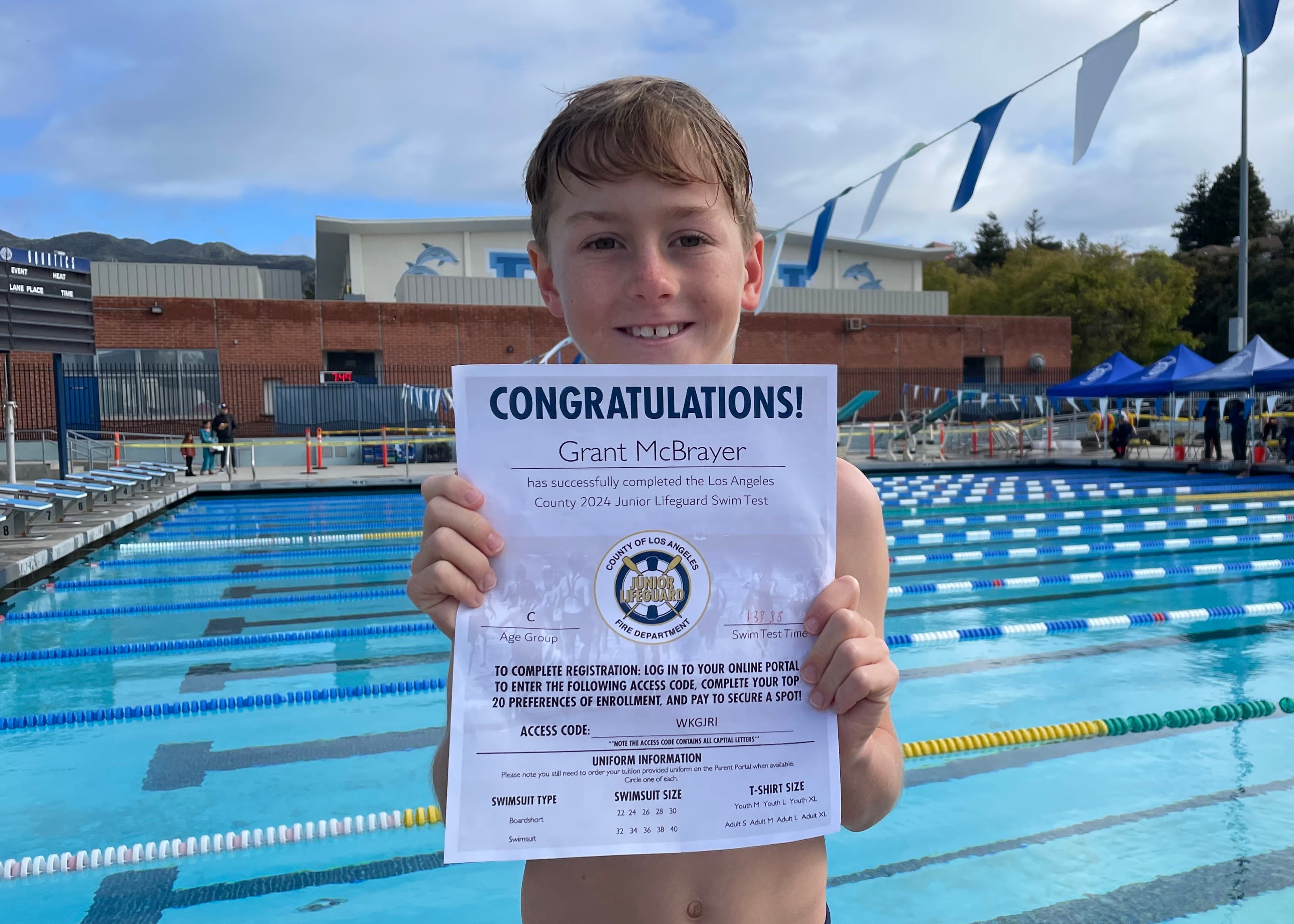 Junior Lifeguard candidate poolside with his swim test certificate
